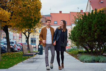 Couple walking on city street holding hands