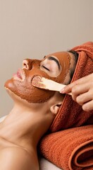 Woman receiving facial mask with spatula, having professional beauty treatment. Skin care and relaxation concept. Day spa procedures.