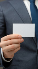 Close up businessman hand showing business card, credit card. Man in suit holding blank business card in a his hand