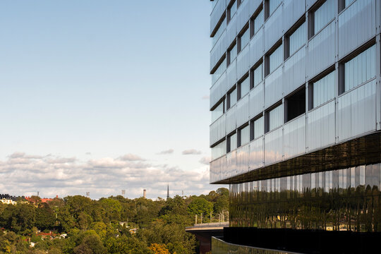 Modern apartment building glass facade with urban reflection in Liljeholmskajen Stockholm for commercial real estate branding