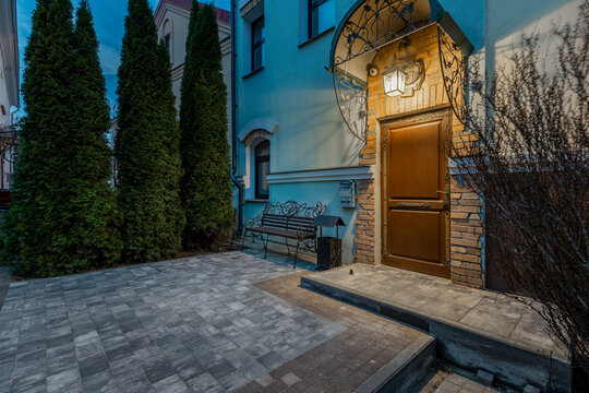 Evening entrance to luxury house with wooden door and lantern