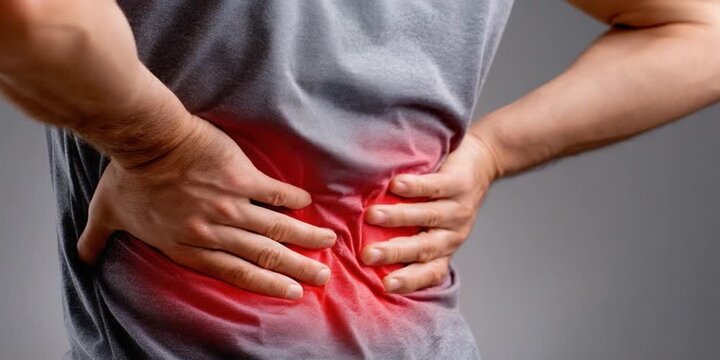 Back Pain: A man's gesture is one of physical torment as he experiences the ache of back pain. His posture reveals the discomfort, highlighting the reality of a physical ailment. 
