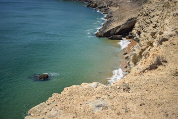 View from coastal cliff down to ocean waves and rock formation