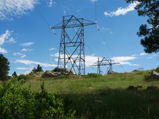 High Voltage Power Transmission Towers and Lines in Sanitas Valley, Boulder, Colorado Under Summer Blue Sky