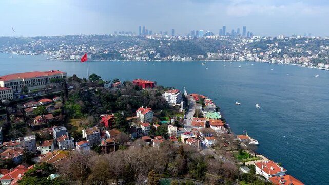 Aerial drone footage of the Kandilli and Vanikoy coastline along the Bosphorus in Istanbul, showing mansions, hillside residences, coastal road, blue waters and the large Turkish flag overlooking the 