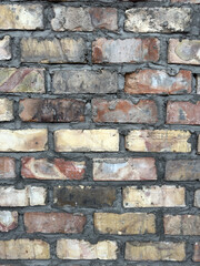 Close up view of a weathered brick wall texture, a vintage construction material for building facade or rustic background.