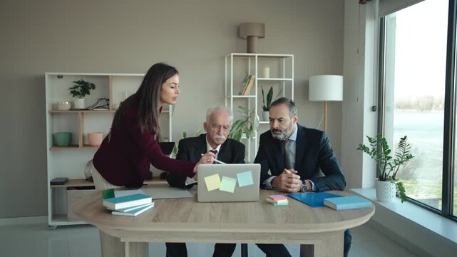 Multi-Generational Business Team Explaining Work to Senior Executive in Modern Office &ndash; Family Business Concept