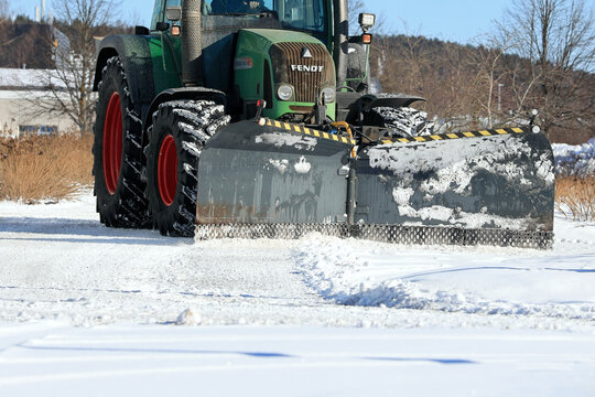 Snow Removal with Fendt 414 Vario Tractor and Snowplow. Copy Space. 