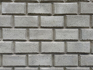 Textured grey cinder block brick wall background. Rough cement construction material for architectural surface pattern and industrial design.
