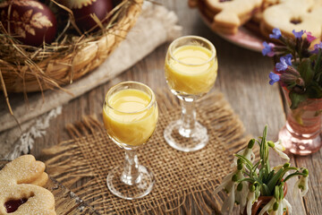 Two glasses of Eiecognac with Easter decoration and spring flowers