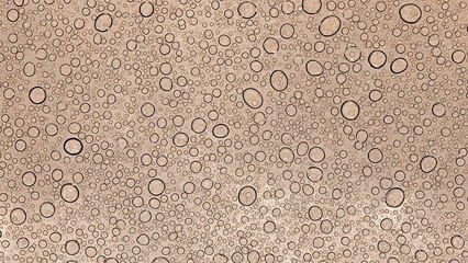 A close up view of water droplets on a textured light brown surface
