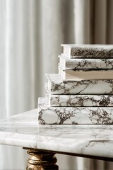 Naklejka premium Stack of marble-patterned books on a marble table, with a gold-toned ornate pedestal leg visible. Concept Marble textures, Marble books, Marble table, Gold-toned pedestal leg, Elegant decor