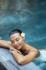 Beautiful Woman Relaxing In Luxury Pool With Tropical Flower In Hair