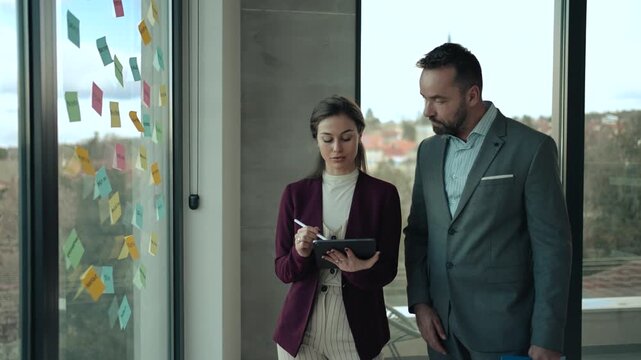 Middle-Aged Man and Young Woman Working in Modern Office with Sticky Notes &ndash; HR and Creative Concept