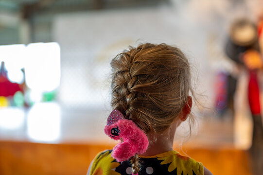 selective focus on the braided hair and scrunchy in a small girl looking forward