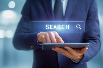 Businessman using a digital tablet with a virtual search interface glowing above the screen in a modern office environment for professional research and information