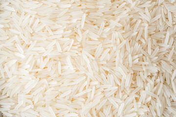 Raw white rice pile on the black stone  background