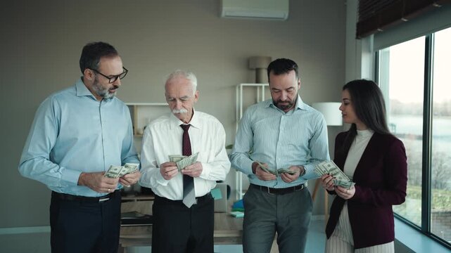 Group of Powerful Businessmen With Money Counting Money in Corporate Office
