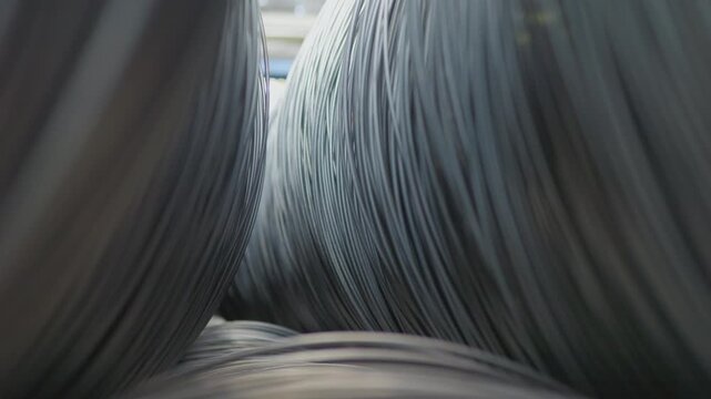 Rows Of Steel Reinforcement Coils Rest In Shadowed Warehouse Ready For Shipping