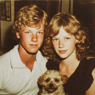 Gar&ccedil;on et fille posant avec un petit chien, photo des ann&eacute;es 80	
