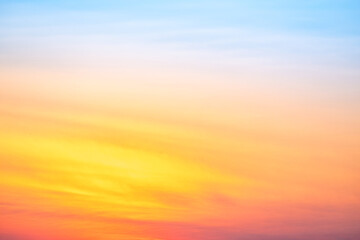 Sunset or sunrise sky with a vibrant gradient of orange, gold, and soft blue. Clear atmosphere with wispy clouds. Peaceful, natural light background. hope, freedom, new day and inspirational Concepts