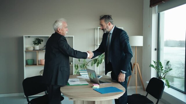 Senior and Middle Aged Businessmen Shaking Hands at the End of Meeting
