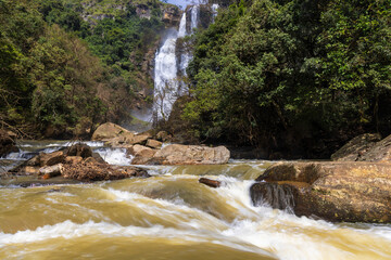 Powerful Bomburu Ella Waterfall Cascading Over Dark Rock in Lush Tropical Forest, Sri Lanka