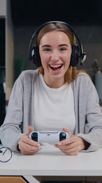 Middle age smilling man playing video game in moderm kitchen apartment enjoying indoor activity. Online entertainment and leisure activity concept.
