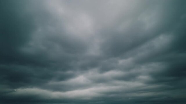 A breathtaking display of swirling, dark grey storm clouds dominates the vast sky, conjuring a profound sense of nature's formidable power and sublime anticipation