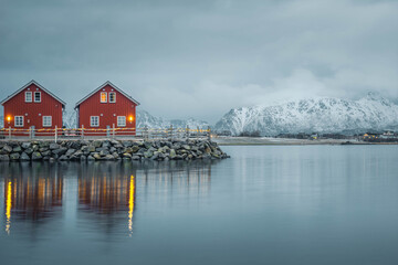 Obraz premium Beautiful vibrant sunrise sky over Reine town with fishing village and snow covered mountain in winter at Lofoten Islands, Norway