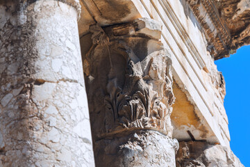 Intricate details of ancient Roman temple architecture, specifically its ornate Corinthian capital...