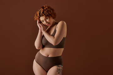 Curvy woman with short curly hair embraces body positivity in studio setting