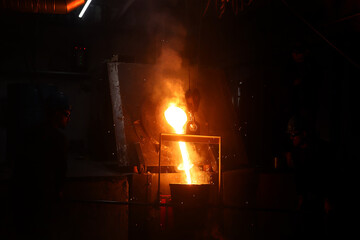 Worker controlling metal melting in furnaces.