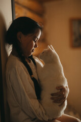 a dark-haired girl with her cat in her arms