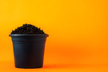 Black Pot Full of Dark Rich Potting Soil Orange