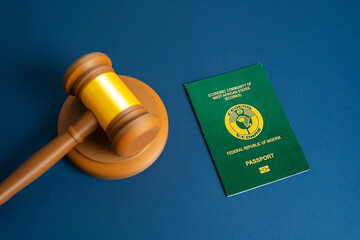 Passport of the Republic of Nigeria and judge's gavel. Court and protection of the rights of citizens. Visa regulation, and migration law enforcement. Citizenship and right of residence.
