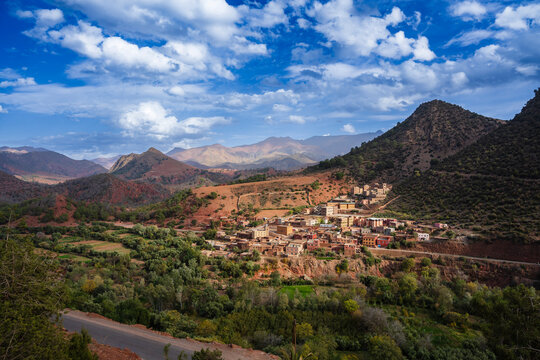 Scenic mountain village under a vibrant blue sky with scattered clouds and lush greenery. Tizi-n-Tichka pass Atlas Mount, Morocco
