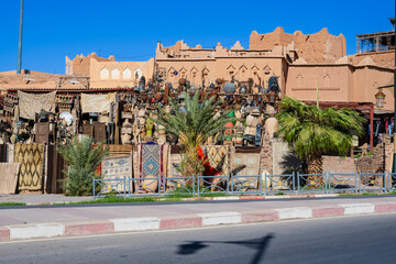 Moroccan market with traditional architecture and outdoor displays on a sunny day. Ouarzazate, Morocco