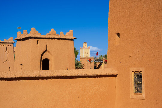 Traditional adobe buildings with blue sky and historic architecture in a desert landscape. Ouarzazate, Morocco