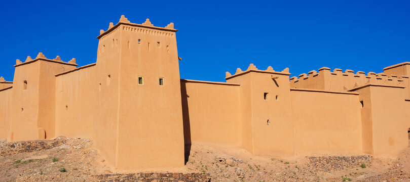 Sunlit ancient adobe fortress with blue sky in the background. Ouarzazate, Morocco
