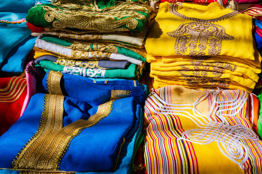 Colorful, intricately embroidered fabrics stacked in vibrant patterns and colors. Rabat, Morocco