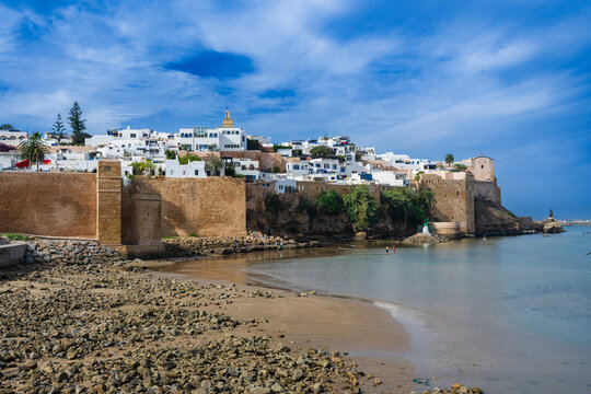 Scenic seaside view of historic white buildings on a hill under a vibrant blue sky. Rabat, Morocco