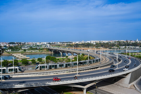 Elevated view of a bridge with cars and trams, overlooking a river and cityscape in daylight. Rabat, Morocco