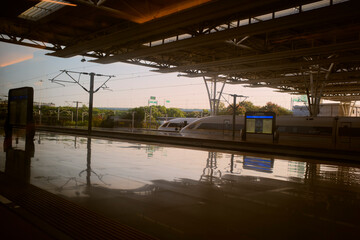 A train station platform with modern architecture and a high-speed train under a vast roof. Chengdu, Sichuan, China