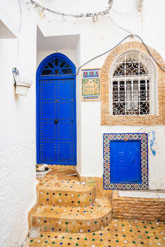 Charming blue door and window on a white wall in a Mediterranean-style street corner. Rabat, Morocco
