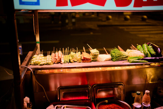 Assorted skewered vegetables and meats displayed at a street food stall during the night. Chengdu, Sichuan, China
