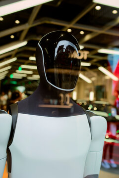 Futuristic humanoid robot displayed in a modern tech showroom with reflective surfaces. Chengdu, Sichuan, China