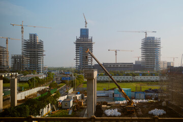 Urban construction site with cranes and tall buildings under a clear blue sky Chengdu, Sichuan, China