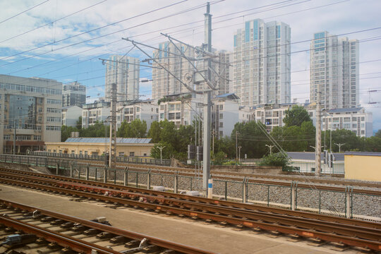 Urban skyline with modern high-rise buildings behind railroad tracks under a bright sky. Chengdu, Sichuan, China