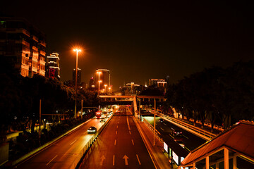 A nighttime cityscape with lit buildings and a busy road illuminated by streetlights. Guangzhou, Guangdong, China